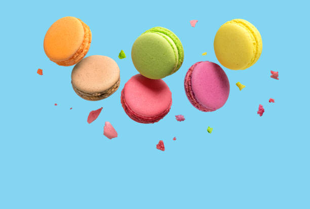 istock Colorful macaroons or macarons falling or flying over blue background. Copy space. 1209504322