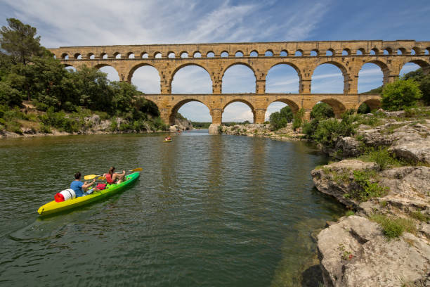 Pont du Gard, Provence, France - Jun 05, 2017: People kayaking on the Gardon river at the Pont du Gard, an ancient Roman aqueduct, near Nimes