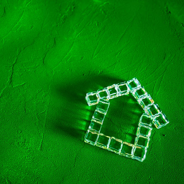 House made of ice cubes on a green background, the concept of real estate and ecology House made of ice cubes on a green background, the concept of real estate and ecology hypothecary stock pictures, royalty-free photos & images