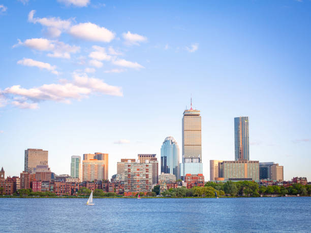 barca a vela sul fiume charles di fronte alla città di back bay boston skyline - back bay immagine foto e immagini stock