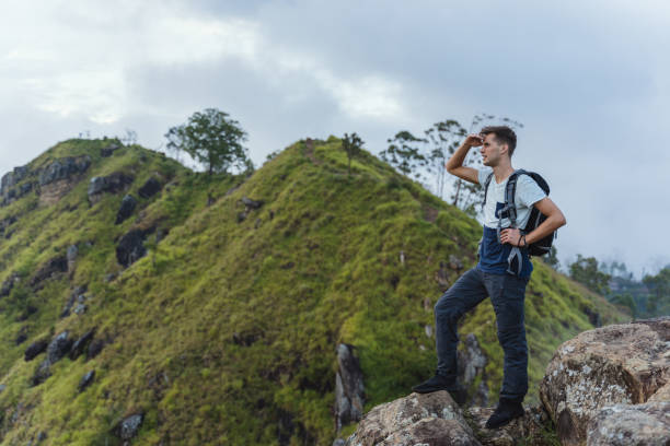 молодой человек наблюдает за панорамой с вершины горы в элле в шри-ланке. - малый пик адама стоковые фото и изображения