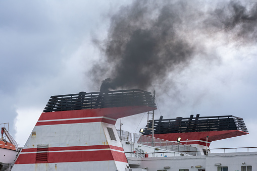 Ship chimneys expelling black smoke when starting engines