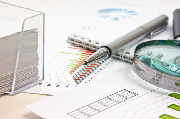 istock pen, magnifying glass and the working paper with a diagram 1209522603