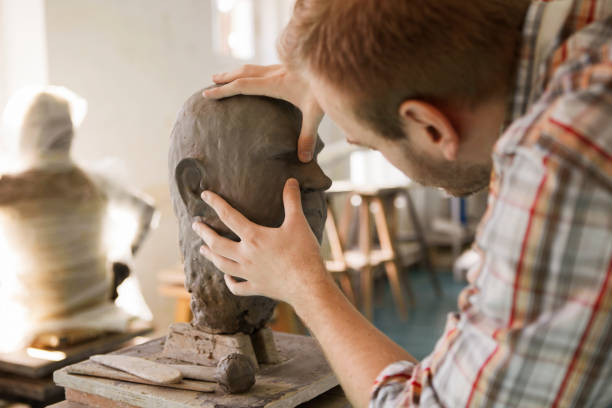 istock Sculptor working on his clay head sculpture shaping face 1209522734