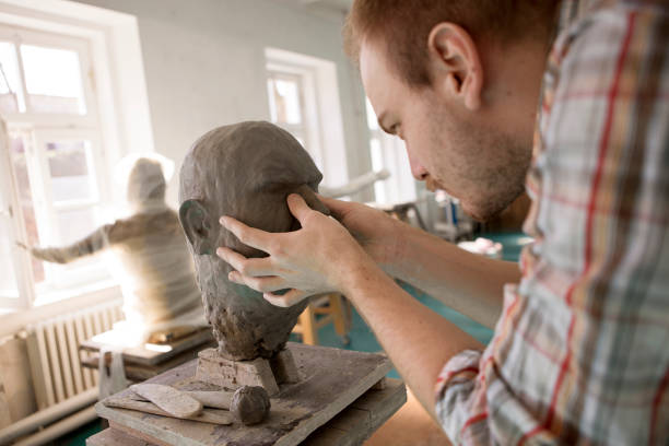 istock Sculptor working on his head sculpture made out of clay 1209522738