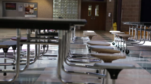 Slow Tracking Shot Of Empty Chairs In School Cafeteria