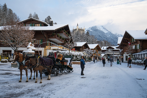 Horse carriage on the promenade of snowy village. Gstaad, Switzerland - 01.01.2019