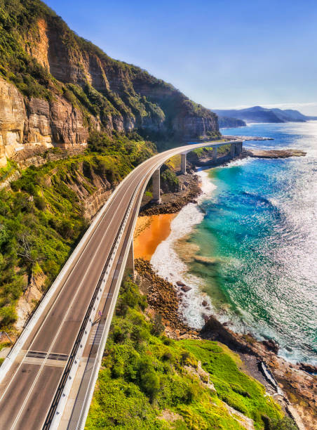 D GPD Br Vert Pan 2 North Grand pacific driver with Sea cliff bridge on Australian Pacific coast in aerial vertical panorama. clifton stock pictures, royalty-free photos & images