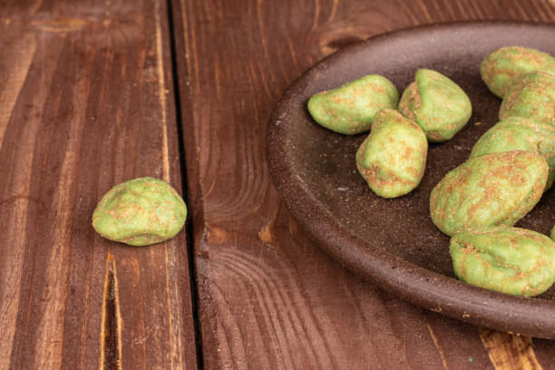 istock Green wasabi peanut on brown wood 1209537426