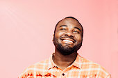 Portrait of a very happy young man with big smile looking up, isolated on colorful background