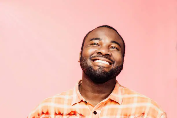 Photo of Portrait of a very happy young man with big smile looking up, isolated on colorful background