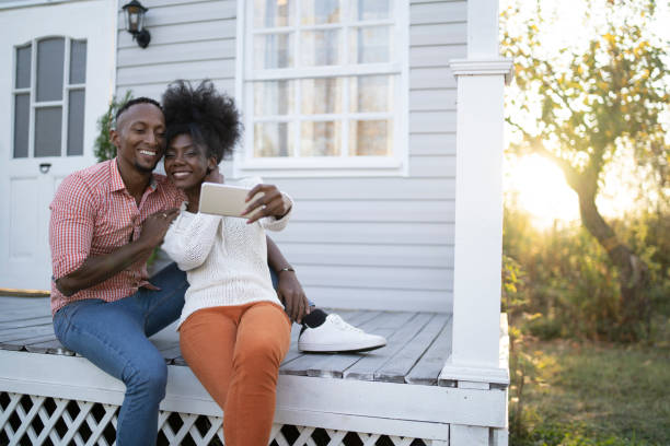 istock Couple sitting outdoors and photo messaging 1209553082