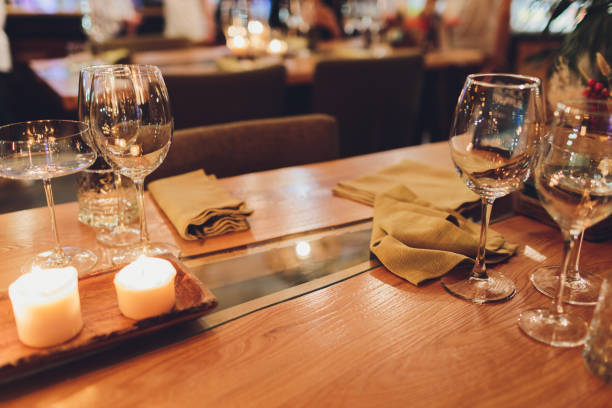 Romantic Wine Glass with Burning Candles and glasses of wine on table in darkness.