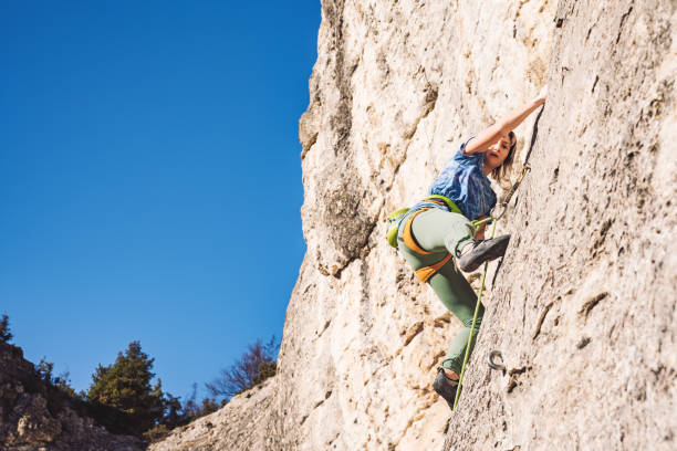 istock Woman climbs a rock. 1209553829