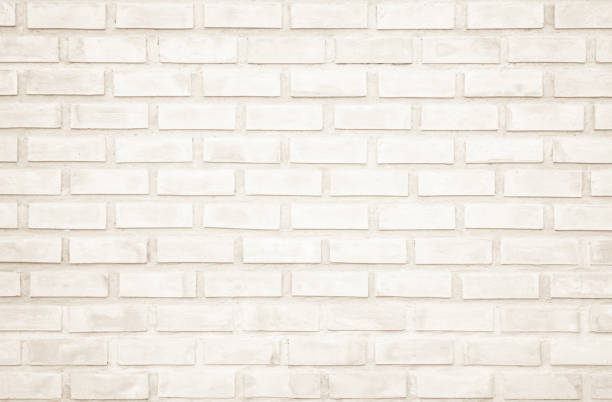 istock Background of wide cream brick wall texture. Old brown brick wall concrete or stone wall textured, wallpaper limestone abstract flooring/Grid uneven interior rock. Home or office design backdrop. 1209554019