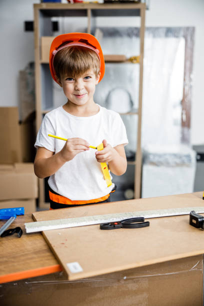 istock Cheeful boy in helmet with instruments stock photo 1209555310