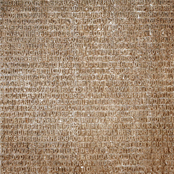 Ancient Latin writing background. Antique inscription carved on stone wall. Old classic script text close-up. Grunge surface with historic letters. Vintage texture with words from past civilization.