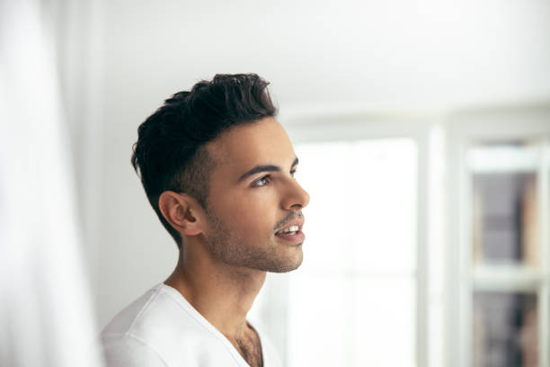 istock Smiling young male is posing at home 1209560663