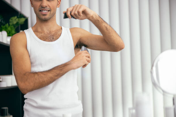 istock Handsome guy standing with deodorant in room 1209561264