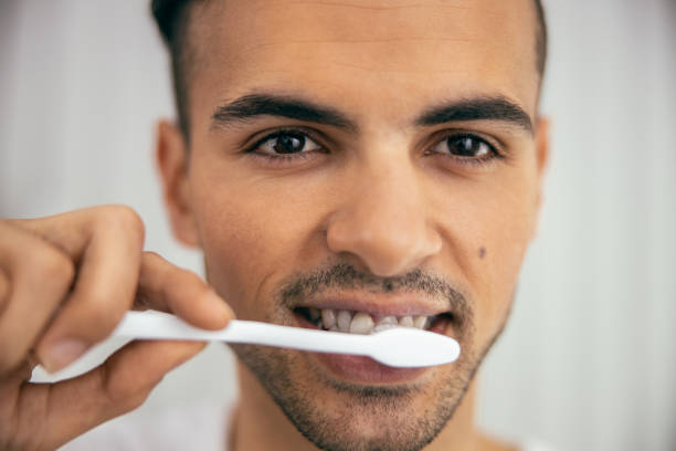 istock Handsome young man cleaning his teeth in bathroom 1209564589