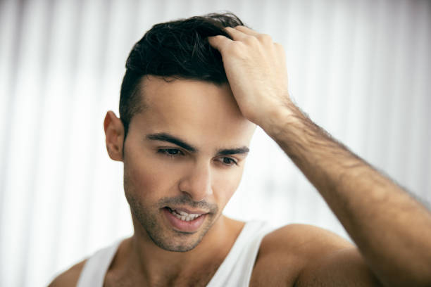 istock Smiling guy is combing his hair with fingers 1209564623