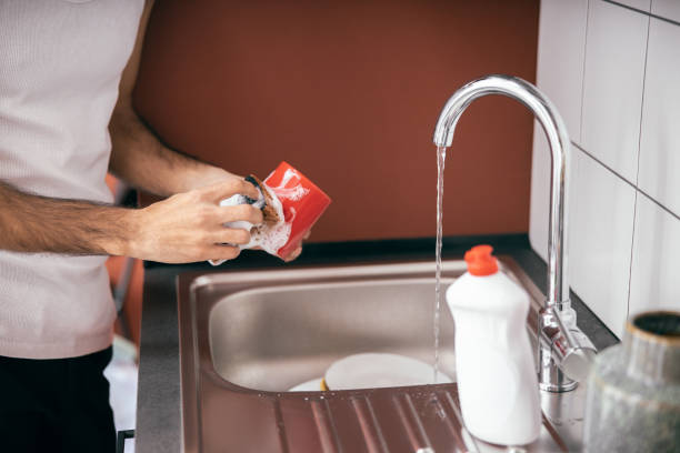 istock Close up of man washing dishes in kitchen 1209564680
