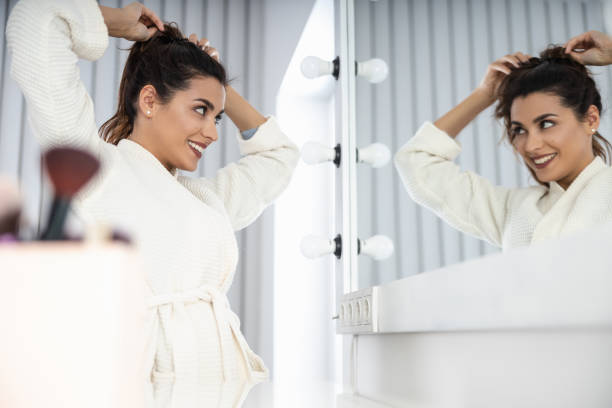 istock Smiling pretty woman looking in mirror at home 1209569400