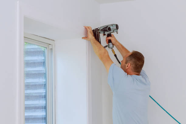 istock Carpenter using air nail gun to moldings for window, close up on nail gun 1209571076