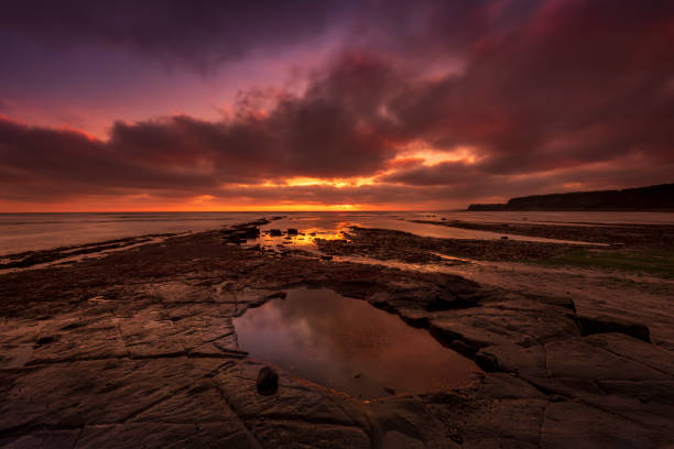 Reflection of sky and clouds in puddle on the beach, Tamarama, Sydney Australia