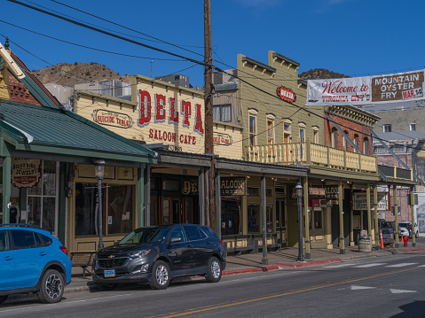 Virginia City, Nevada - February 22, 2020: Delta saloon and Sawdust corners, stores, and a banner advertising a \