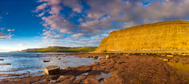 istock Kimmeridge panorama - glowing golden cliffs illuminated in the sunshine 1209581073