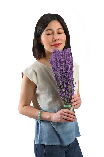 Asian woman smelling lavender flowers