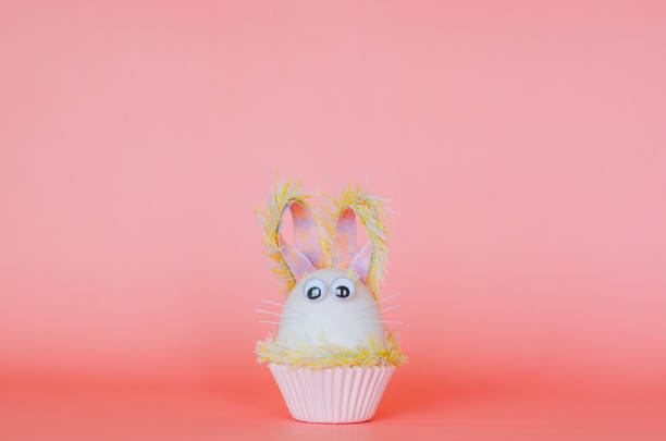 istock Easter egg decorates as bunny dressing put on colorful cupcake paper cup. 1209592410
