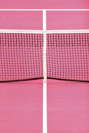 Tennis net and centre service line on pink court