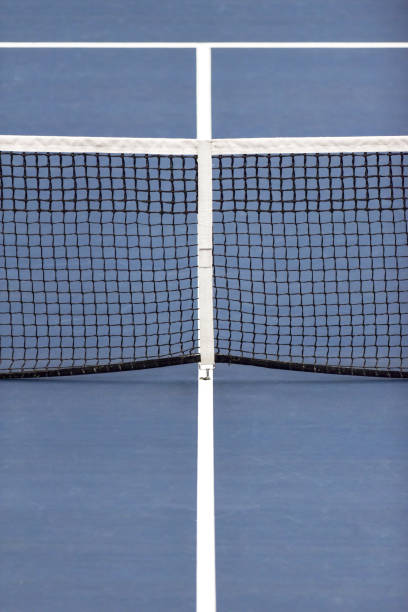 istock Tennis net and centre service line on blue court 1209593203