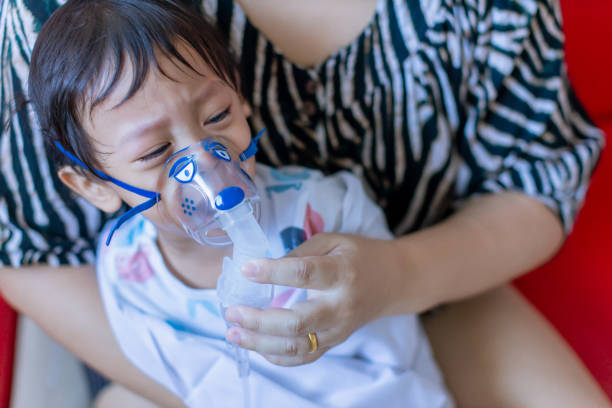 Sick boy inhalation therapy by the mask of inhaler. Baby has asthma and need nebulizations. Patient Boy use inhalation with Nebulizer mask at hospital. The baby are spraying bronchodilators . covid 19 terapia de inhalación de niño enfermo por la máscara del inhalador. el bebé tiene asma y necesita nebulizaciones. el niño paciente usa inhalación con máscara de nebulizador en el hospital. el bebé está rociando broncodilatadores. covid 19