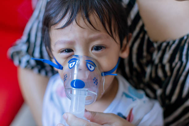 Sick boy inhalation therapy by the mask of inhaler. Baby has asthma and need nebulizations. Patient Boy use inhalation with Nebulizer mask at hospital. The baby are spraying bronchodilators . covid 19 terapia de inhalación de niño enfermo por la máscara del inhalador. el bebé tiene asma y necesita nebulizaciones. el niño paciente usa inhalación con máscara de nebulizador en el hospital. el bebé está rociando broncodilatadores. covid 19