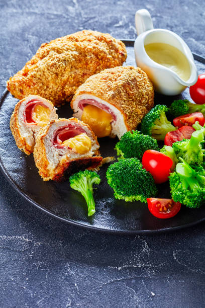 pollo cordon bleu horneado en horno con relleno de jamón y queso - cordoning fotografías e imágenes de stock