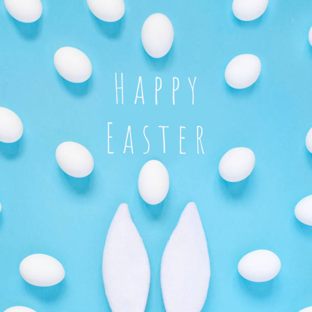 Easter concept. Rabbit ears and white eggs. On a blue background.