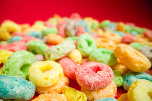 istock Macro Close-Up Bright Wide Low Angle Shot of Sugary Colorful Fruit Loop American Breakfast Cereal Spread Out on a Red Background 1209611578