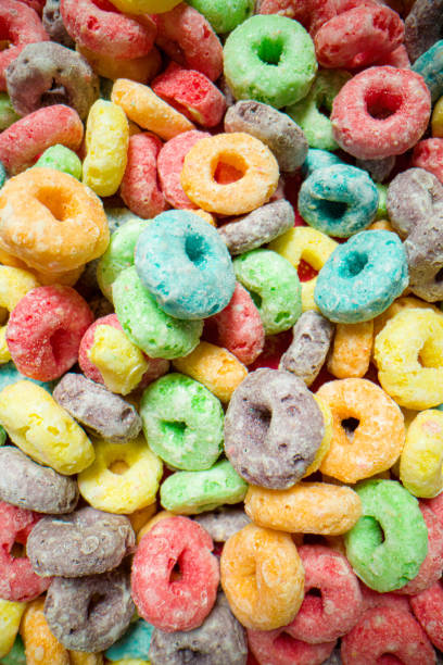 istock Macro Top-Down High Angle Above Shot of Sugary Colorful Fruit Loop American Breakfast Cereal Spread Out on a Red Background 1209611593