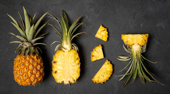Fresh cut pineapple on black background, top view, copy space, banner
