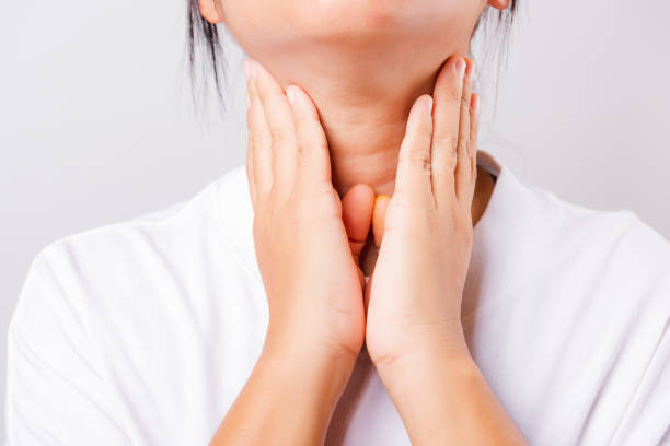 istock Asian beautiful woman Sore Throat or thyroid gland problem her useing Hand Touching Ill Neck on white background 1209619765