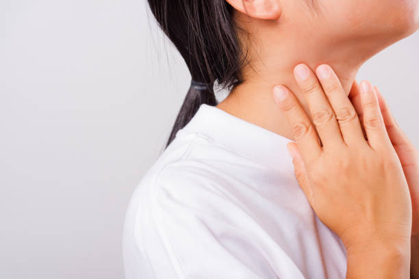 istock Asian beautiful woman Sore Throat or thyroid gland problem her useing Hand Touching Ill Neck on white background with copy space 1209619779