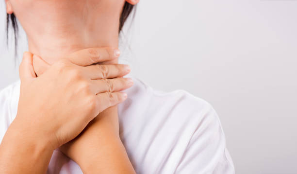 istock Asian beautiful woman Sore Throat or thyroid gland problem her useing Hand Touching Ill Neck on white background 1209619782