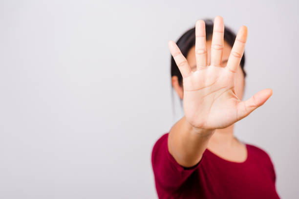 istock Asian beautiful woman itching her outstretched hand showing stop gesture front face, focus on hand 1209619795