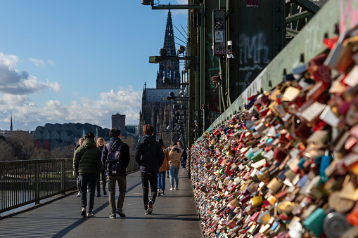 Cologne, Germany - feb 25.2.2020: Lovers locks are covering the railings of Hohenzollern bridge in Cologne. The bridge is a propitious locations since it's right next to famous Cologne Dome.