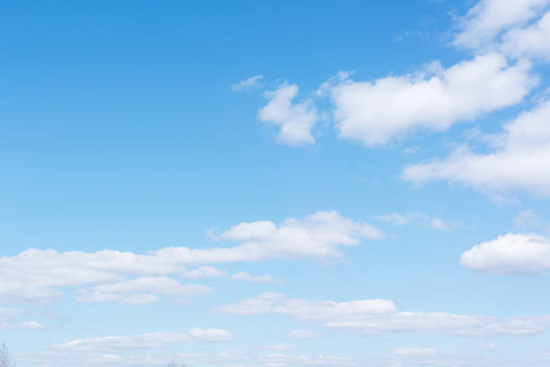 White cumulus clouds against the background against blue on a blue background. A clear sunny day. Bright colours