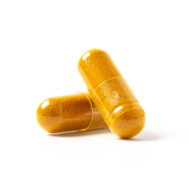 ハーブカプセルオレンジハーブ孤立白の背景 - capsule pill white nutritional supplement ストックフォトと画像