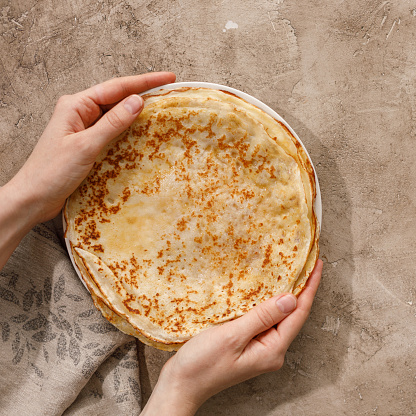 Delicious homemade pancakes with honey on a textural background. Top view, close-up. Traditional holiday celebration concept. Russian translation wide and happy Maslenitsa.